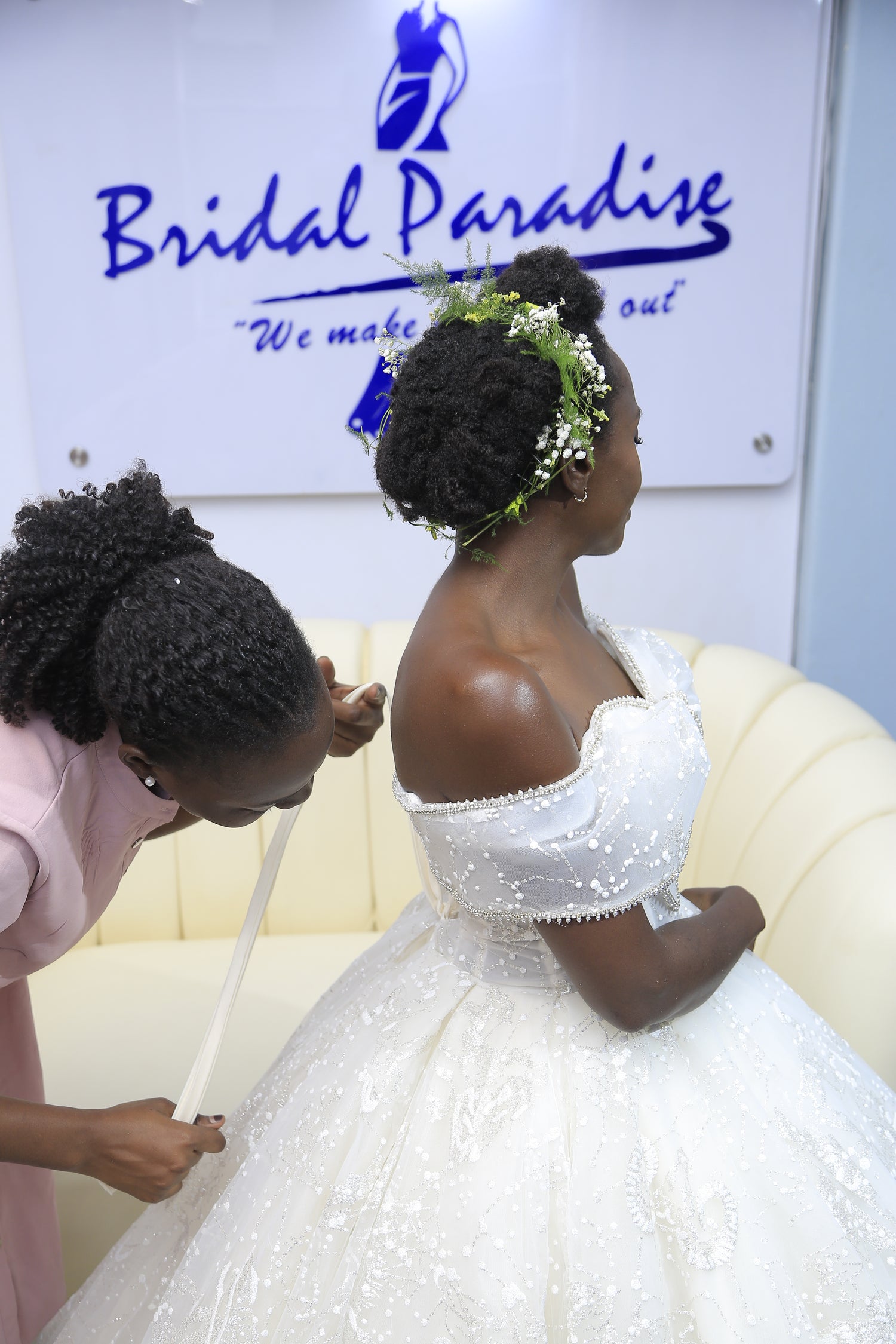 one woman is tailor measuring the bride
's gown sizes emphasing professionalism at bridal paradiseug